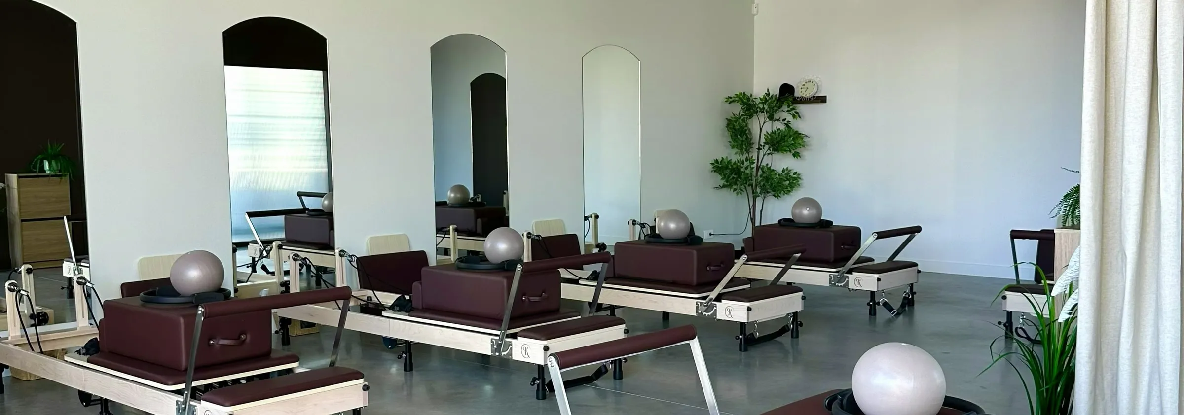 Le studio du Kaizen Pilates Club : les reformers alignés face aux miroirs